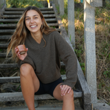 Woman sitting on steps outdoors holding a cup